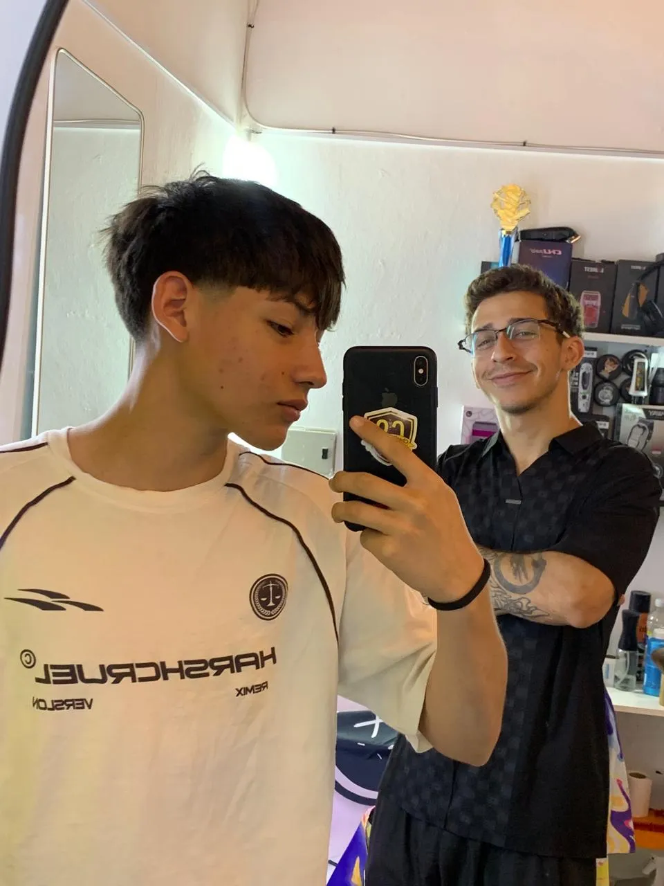 Charlie mostrando el resultado del corte al cliente en el espejo